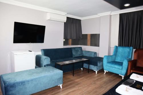 a living room with blue furniture and a flat screen tv at GRAND ONUR HOTEL in Istanbul