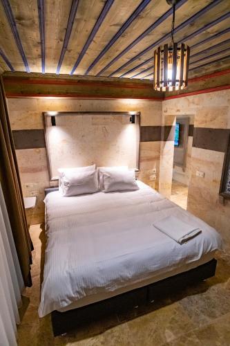 a bedroom with a large white bed and a chandelier at Uçhisar Premium in Nevsehir