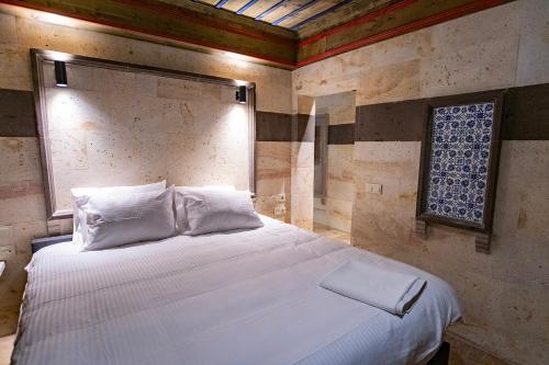 a bedroom with a white bed with a window at Uçhisar Premium in Nevsehir