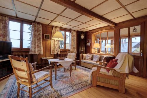 a living room with a couch and a table at Fauvettes in Chateau-d'Oex