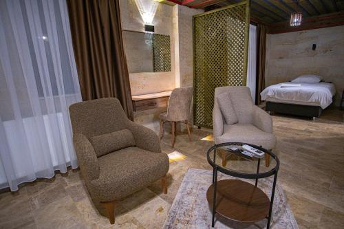 a living room with chairs and a bed and a table at Uçhisar Premium in Nevsehir