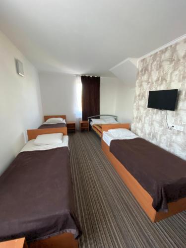 a hotel room with two beds and a flat screen tv at Autopark Hotel in Lviv
