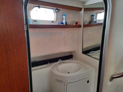 une petite salle de bain avec un lavabo et un miroir dans l'établissement Bateau à quai port hendaye, à Hendaye