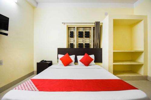 una camera da letto con un grande letto con cuscini rossi di Pradhan Palace a Cuttack