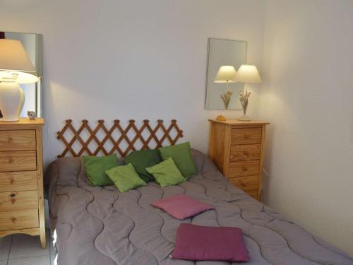 a bedroom with a bed with green and pink pillows at Appartement Cap d'Agde, 3 pièces, 7 personnes - FR-1-249-44 in Cap d'Agde