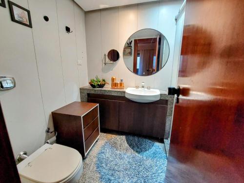 een badkamer met een toilet, een wastafel en een spiegel bij Bonaparte hotel D411 in Brasilia