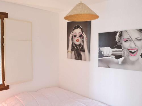 une chambre avec deux photos d'une femme sur le mur dans l'établissement Appartement 2 pièces cabine, piscine, tennis, proche plage Richelieu, Cap d’Agde, 6 personnes - FR-1-249-87, au Cap d'Agde