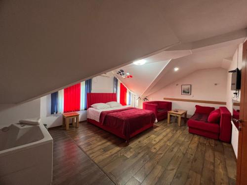 a bedroom with a bed and two red chairs at Prenoćište SAMIR in Gradačac