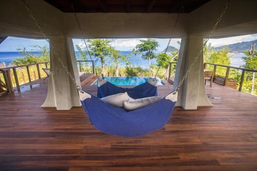 a blue hammock on a deck with a view of the ocean at Secret Bay in Portsmouth