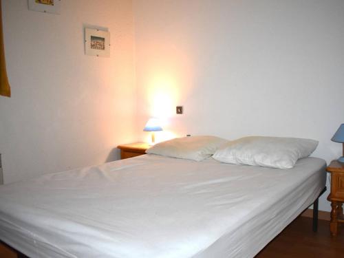 um quarto com uma cama branca e 2 almofadas em Appartement Font-Romeu-Odeillo-Via, 2 pièces, 6 personnes - FR-1-580-19 em Font Romeu Odeillo Via