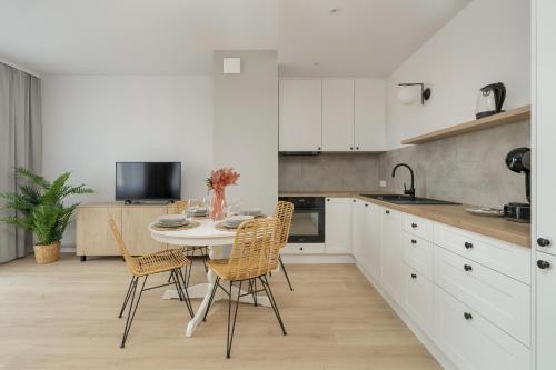 a kitchen with a table and chairs in it at Elegant Apartment for 4 with Parking in Poznan by Renters in Poznań