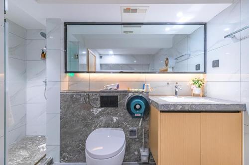 a bathroom with a toilet and a sink and a mirror at Kunming Dianchi Mideel International Apartment - South Asian Style Fuhai Metro in Kunming