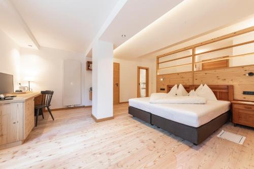 a bedroom with a large bed and a desk at Hotel Tann in Collalbo