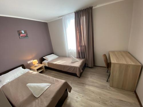 a hotel room with two beds and a window at Autopark Hotel in Lviv