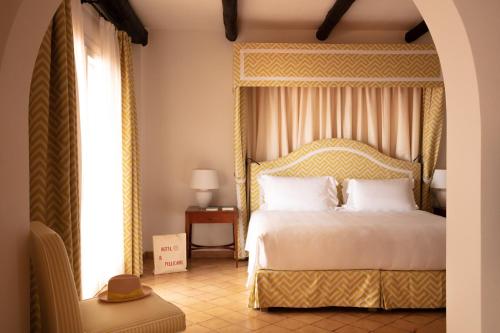 a bedroom with a bed with a gold canopy at Il Pellicano in Porto Ercole