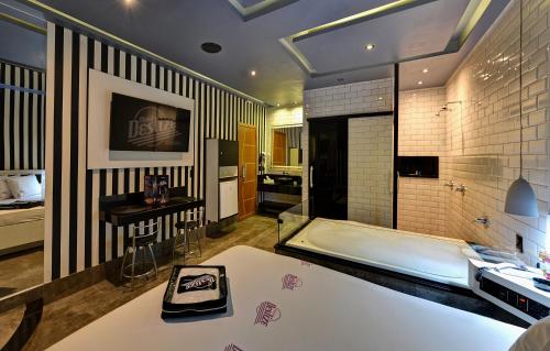 a large bathroom with a tub and a sink at Motel Deslize Ribeirão Preto in Ribeirão Preto