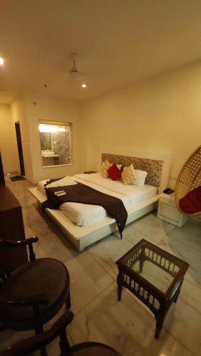 a bedroom with a bed and a chair at Hotel VRS INNS in Chandīgarh