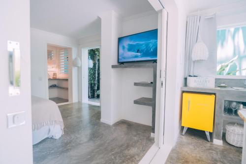 1 dormitorio con 1 cama y TV en la pared en Cactus Lodge Pipa, en Pipa