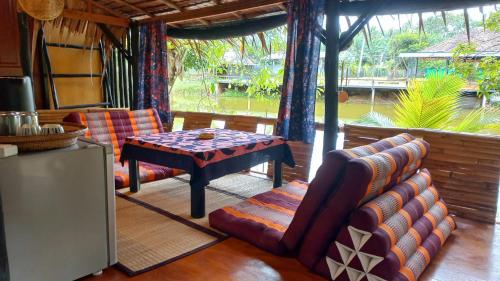 ein Wohnzimmer mit einem Sofa und einem Tisch in der Unterkunft Bar Horizon Hostel in Chumphon