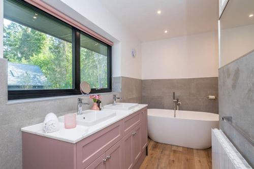 uma casa de banho com uma banheira e um lavatório e uma banheira em Rural retreat by the river em Norwich