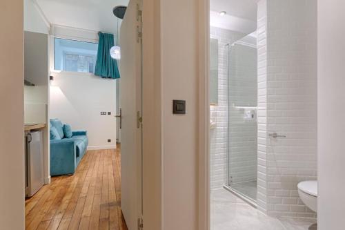 La salle de bains est pourvue d'une douche et d'un canapé bleu. dans l'établissement Luxury LOFT 6P - Arc de Triomphe, à Paris