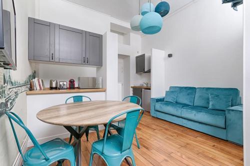un salon avec une table et des chaises et un canapé bleu dans l'établissement Luxury LOFT 6P - Arc de Triomphe, à Paris
