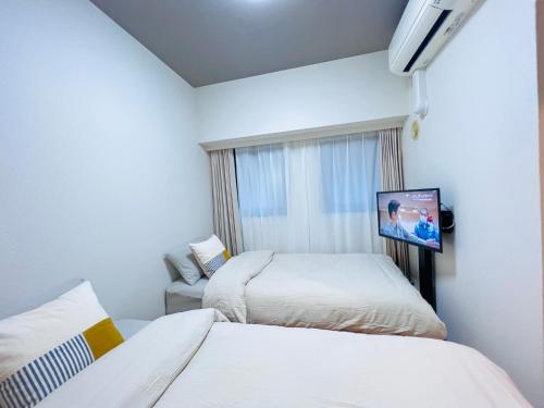 een hotelkamer met 2 bedden en een televisie bij Jun KBK- 606 in Tokyo