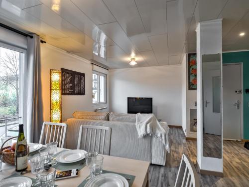 a living room with a couch and a table with chairs at Cosy apartment on Strasbourg Tramway line and Canal - Appartement confortable sur ligne tram Strasbourg et Canal in Bischheim