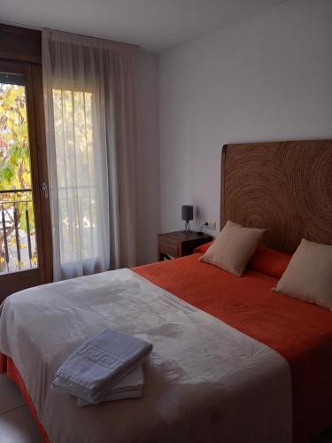 a bedroom with a large bed with towels on it at Apartaments Bell-Lloc Puigcerda in Puigcerdà
