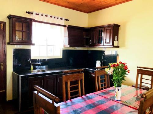 una cucina con un tavolo con un vaso di fiori sopra di Shevyhaws a Nuwara Eliya