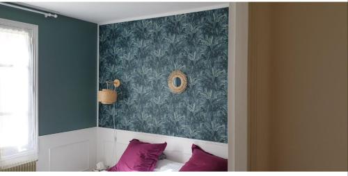 a bedroom with a wall with a green wallpaper at Halte au beau Millet in Coutras