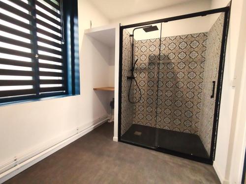 a shower with a glass door in a room at Résidence Beaudelot in Saint-Saulve
