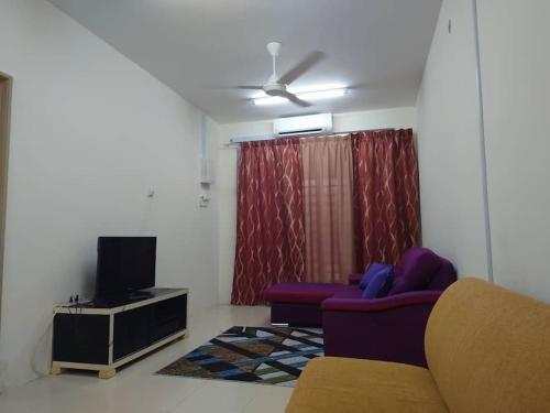 a living room with a couch and a tv at Nourina Homestay Gambang in Gambang