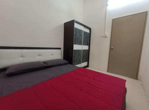 ガンバンにあるNourina Homestay Gambangのベッドルーム1室(赤毛布付きの大型ベッド1台付)
