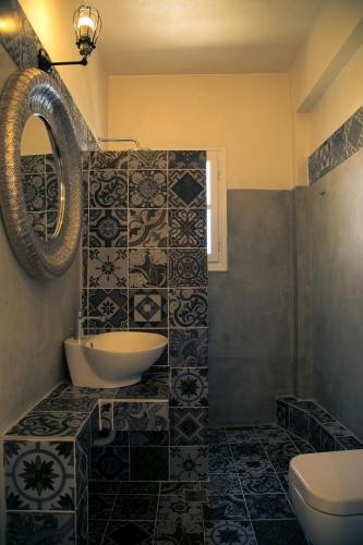 a bathroom with a sink and a toilet and a mirror at Eos Villa in Imerovigli