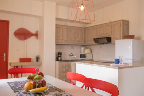a kitchen with a table with a bowl of fruit on it at Eos Villa in Imerovigli