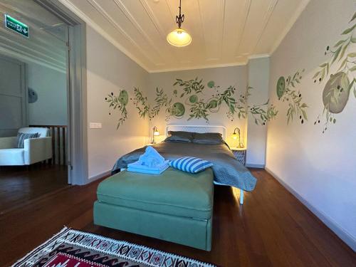 a bedroom with a bed with a blue ottoman in it at Tilas - Rooms in 19th Century Wooden Townhouse,Kadikoy in Istanbul