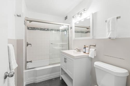 a white bathroom with a sink and a shower at House at Phipps in Atlanta