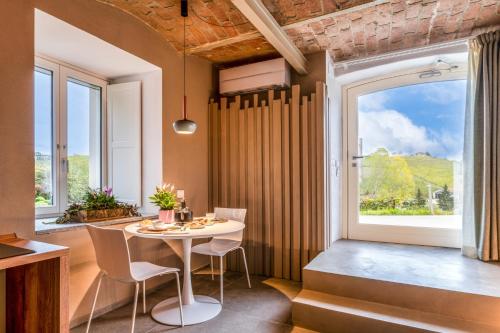 a dining room with a table and chairs and a large window at Langhe Country House in Neive
