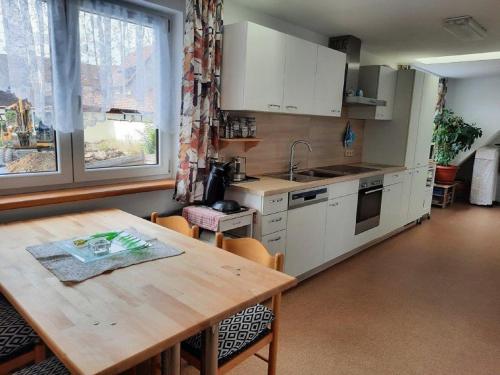 a kitchen with a wooden table and a table and chairs at Ferienwohnung Neue Schmiede in Helmershausen