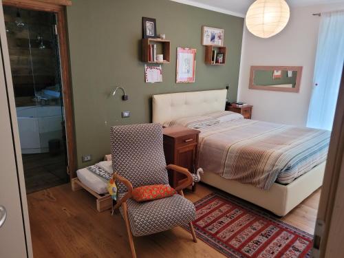 1 dormitorio con cama, silla y escritorio en VALDISOLE-home, en Ossana