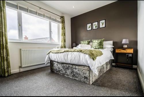 a bedroom with a large bed and a window at 3 Bed House, Perfect for Business and Contractors in Nottinghamshire in Plumtree
