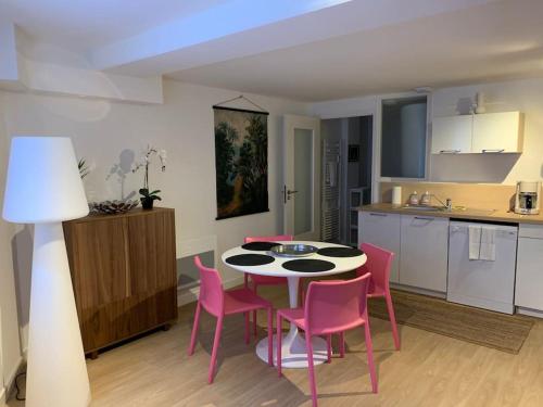 uma cozinha com uma mesa e cadeiras cor-de-rosa num quarto em Jaurès - Centre-Ville - T3 au calme em Brest