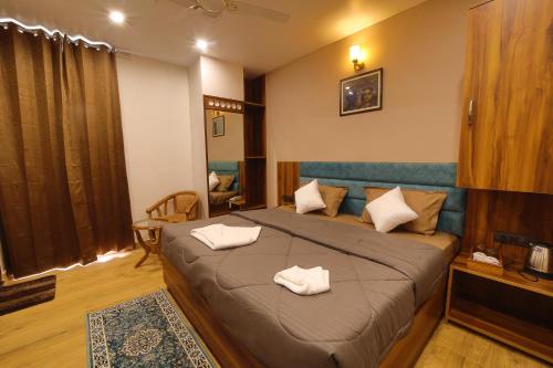 een slaapkamer met een bed met twee handdoeken erop bij Hotel Mahadev Rishikesh in Rishīkesh