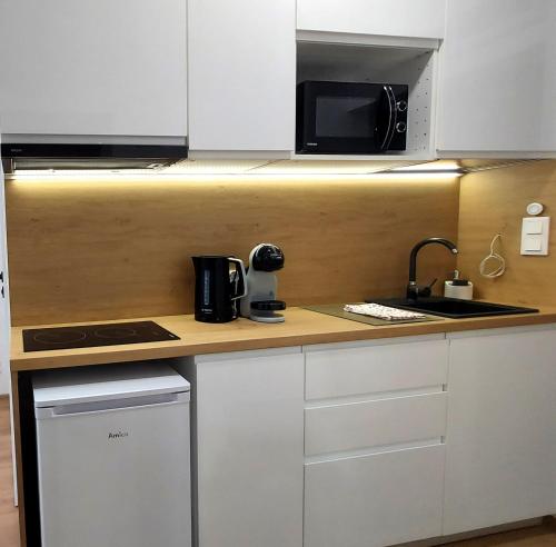 a kitchen with a counter top with a microwave at theApartments Gdańska in Łódź