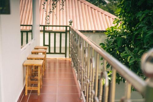 balcón con sillas de madera y barandilla en Phòng Mơ - Nhà Mơ Homestay Bến Tre, en Ben Tre