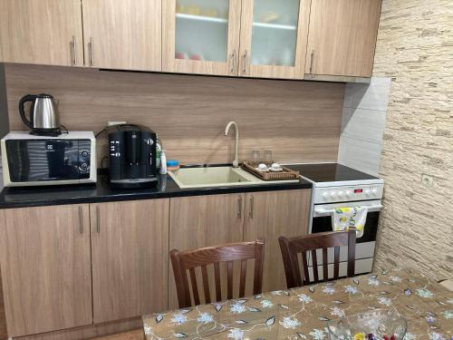 a small kitchen with a sink and a microwave at Уютен апартамент Мечта in Vratsa