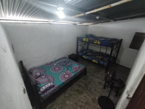 a room with two beds and a shelf in it at Hospedaje los polos in Villavieja