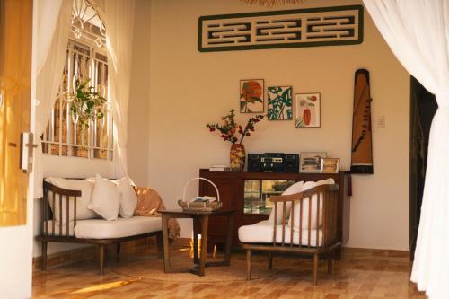 a living room with two chairs and a table at Phòng Dừa - Nhà Mơ Homestay Bến Tre in Ben Tre