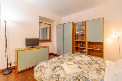 Schlafzimmer mit einem Bett und einem Schrank mit einem TV in der Unterkunft Residenza Juvarra - Exclusive Flat in Turin